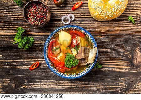 Shurpa Soup In Plate With Oriental Ornament, Wooden Background. Top View. Traditional Asian, Uzbek, 