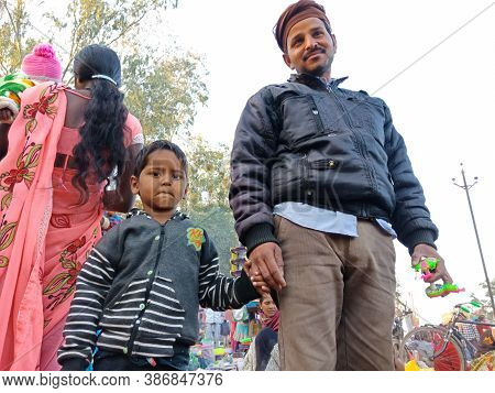 District Katni, India - February 02, 2020: Indian Village Little Kid Holding His Father Hand At Trad