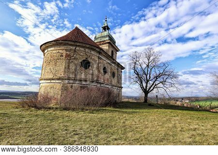 Old Church Buildind With Cracked Walls And Bald Tree In Autumn
