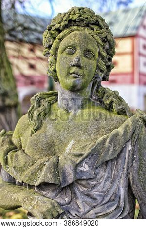 Detail Of Old  Green Moss Covered Statue Of The Girl With Flowers Wreath On Her Head