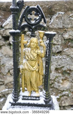 Detail Of The Gold Colored Metal Figure Of Saint Man With Black Arcade