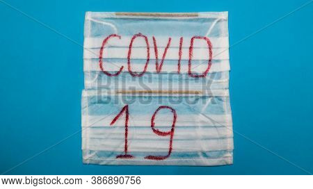 Typical White 3-ply Surgical Mask With Rubber Earhooks To Cover Mouth And Nose With English Block Le