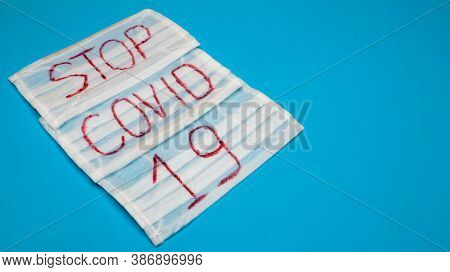 Typical 3-ply White Surgical Mask With Rubber Earhooks To Cover Mouth And Nose With English Block Le