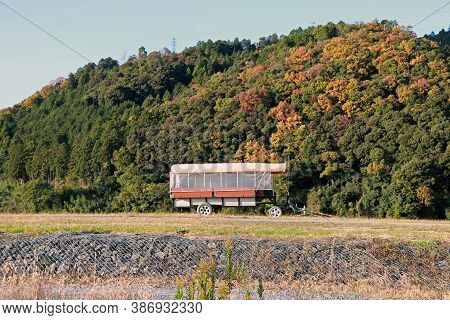 The Trailer On The Grassy Hill And Background Mountain Range With Blue Sky. The Drawbar Trailer For 