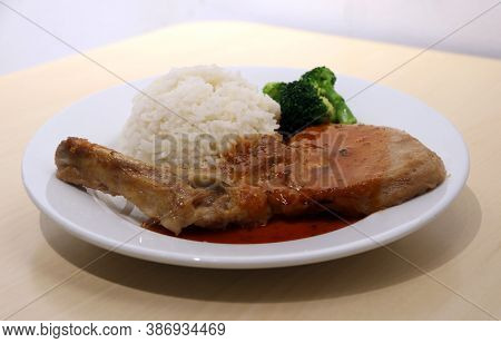 Pork Chop Steak White Rice And Green Broccoli In The Dish On The Wooden Table. Steak Is High Quality