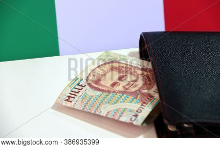 One Thousand Lire Of Italy Banknote With Black Wallet On The White Floor With Italia Flag Background