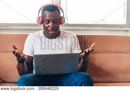 Young Black African Man Relaxing Using Laptop Computer Working And Video Conference Meeting At Home.