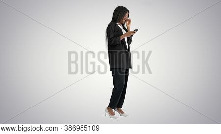 Laughing African American Female Texting On Her Phone On Gradien