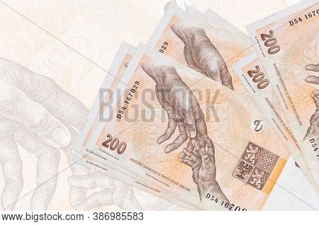 200 Czech Korun Bills Lies In Stack On Background Of Big Semi-transparent Banknote. Abstract Present