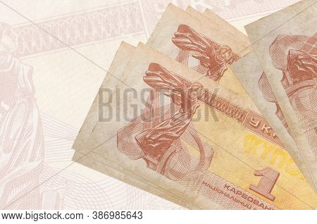 1 Ukrainian Coupon Bills Lies In Stack On Background Of Big Semi-transparent Banknote. Abstract Pres