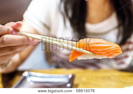 Sushi with chopsticks right hand