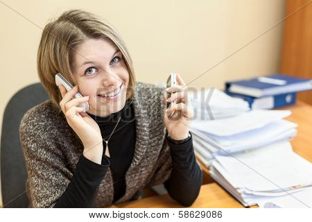 Beautiful Girl Talking On Two Cell Phones At The Same Time