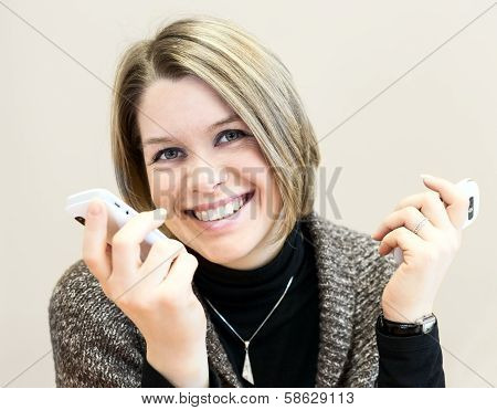 Attractive Happy Young Businesswoman Chatting On Two Smartphones