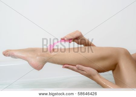 Woman Shaving Her Bare Legs In The Bath