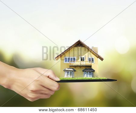 house on ,touch- tablet in a hands 