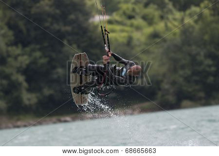 Professional  Kitesurfer Jumps Over The Water During Training On Lake Of Santa Croce