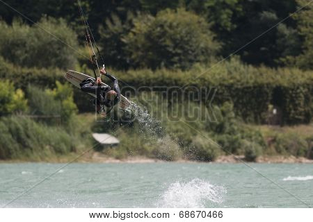 Professional  Kitesurfer Jumps Over The Water During Training On Lake Of Santa Croce