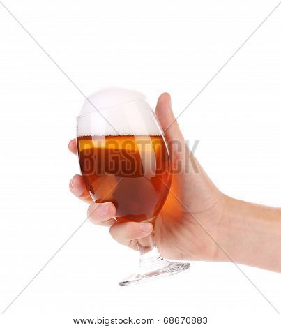 Hand holds glass of beer.