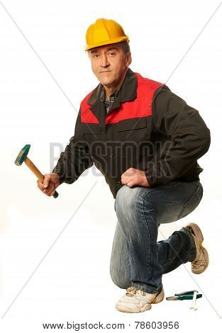 Worker In A Yellow Hard Hat Crouched With A Hammer, Wrench, Pliers