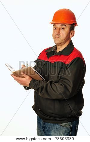 Worker In A Orange Helmet Writes In A Notebook