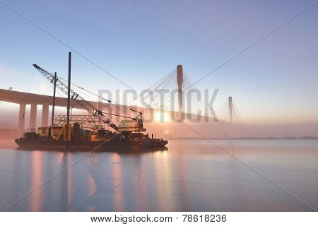 The New Port Mann Bridge and boat lifting crane at sunrise