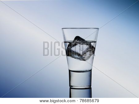 Short Drink Glass With Clear Liquid And Ice Cubes