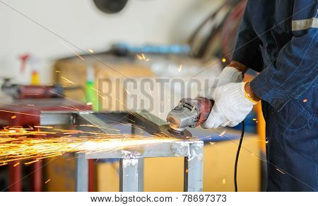 Worker Grinding Steel By Grinding Machine