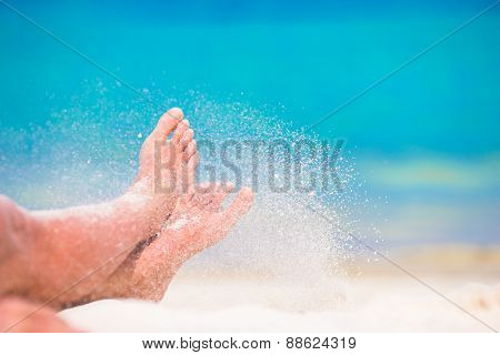Close up of female feet on white sandy beach