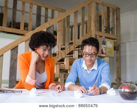 Two desingers working on a project together in office