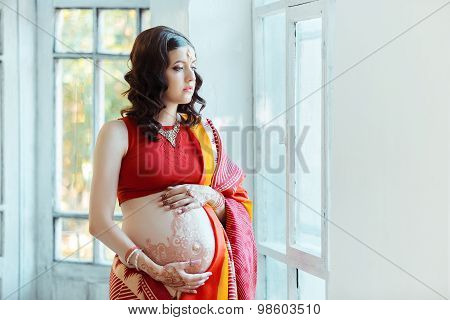 The pregnant woman belly with henna tattoo