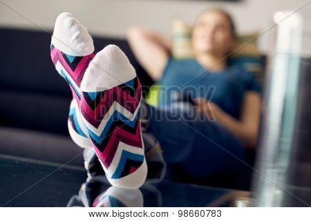 Woman With Feet On Table Watching Film Tv At Home