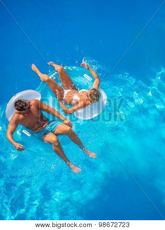 Couple Outside Relaxing In Swimming Pool in the summertime