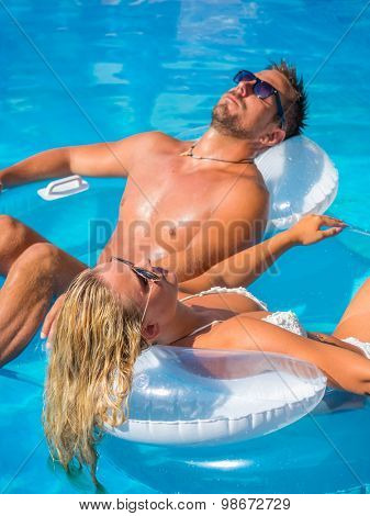 Couple Outside Relaxing In Swimming Pool in the summertime