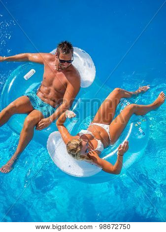 Couple Outside Relaxing In Swimming Pool in the summertime