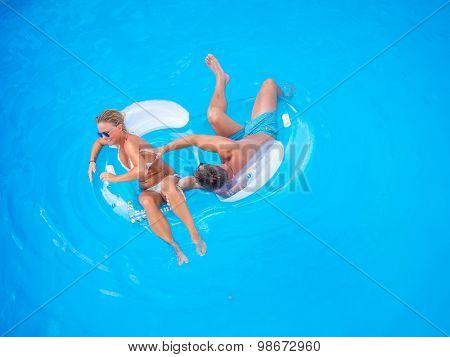 Couple Outside Relaxing In Swimming Pool in the summertime