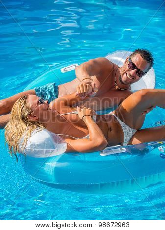 Couple Outside Relaxing In Swimming Pool in the summertime