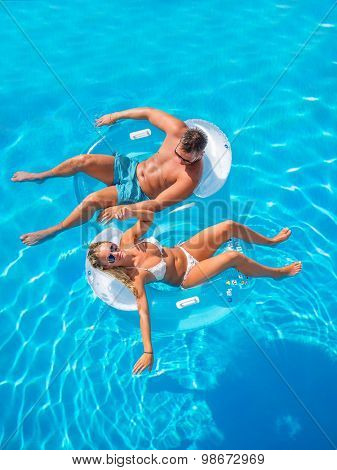 Couple Outside Relaxing In Swimming Pool in the summertime