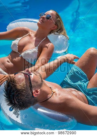 Couple Outside Relaxing In Swimming Pool in the summertime