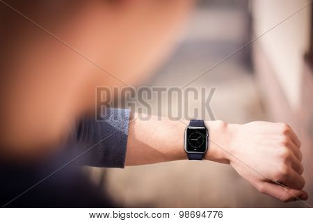 Hand wearing elegant smartwatch with clock app