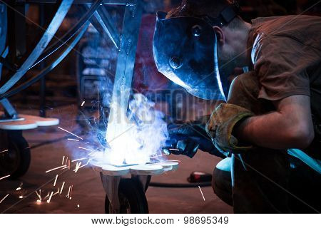 Employee welding using MIG/MAG welder.