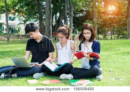 Young Student Asian Group Teenager with school folders on grass at university campus college
