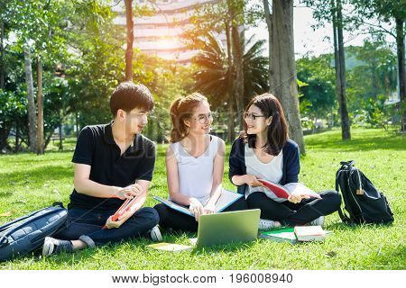 Young Student Asian Group Teenager with school folders on grass at university campus college