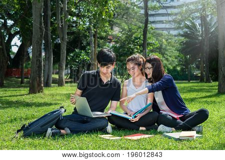 Young Student Asian Group Teenager with school folders on grass at university campus college