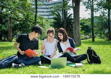 Young Student Asian Group Teenager with school folders on grass at university campus college