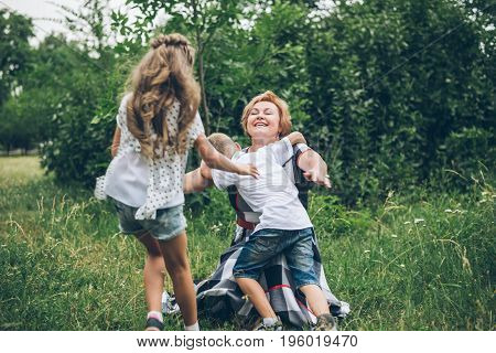 Grandmother playing in the park with grandchildren, siter with brother