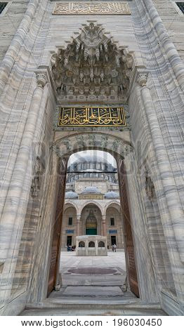 Istanbul Turkey - April 17 2017: Low angle day shot of one of the entrances leading to the court of Suleymaniye Mosque featuring main facade of the mosque and few tourists visiting the mosque