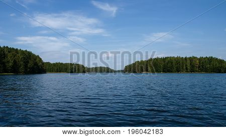 Finnish lake on a clear summer day with lush green islands and coasts