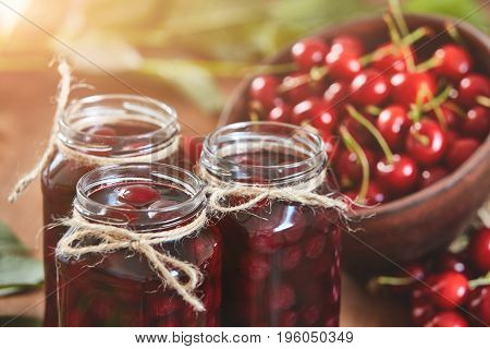Cherry jam on wooden ground with fresh cherries
