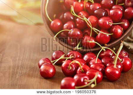 Cherries on wooden table with water drops macro background