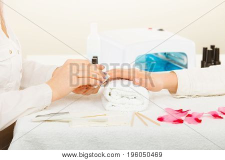 Woman hand on towel preparing gel hybrid manicure using nail polish remover to remove dust and oil from nails. Beauty wellness spa treatment concept